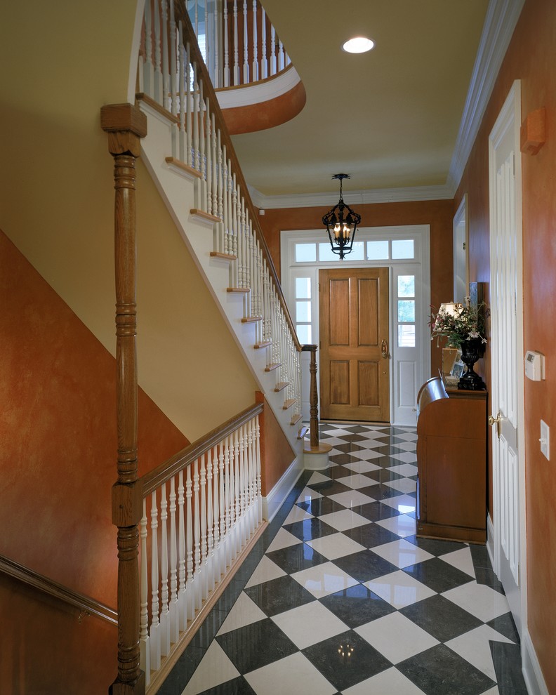 Esempio di un corridoio tradizionale con pareti arancioni e pavimento multicolore