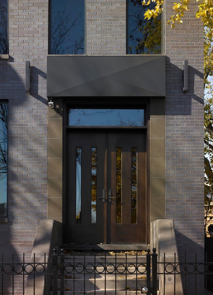 Ejemplo de puerta principal moderna grande con paredes marrones, suelo de piedra caliza, puerta doble y puerta de vidrio