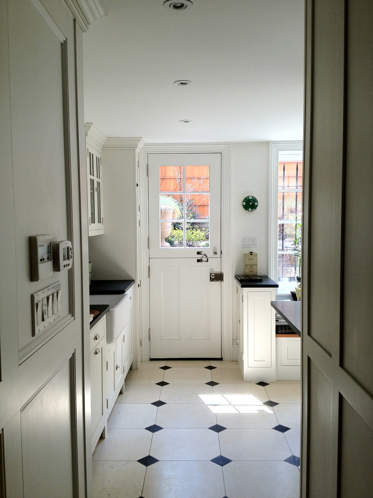 Foto de entrada clásica de tamaño medio con paredes blancas, suelo de piedra caliza, puerta blanca y puerta tipo holandesa
