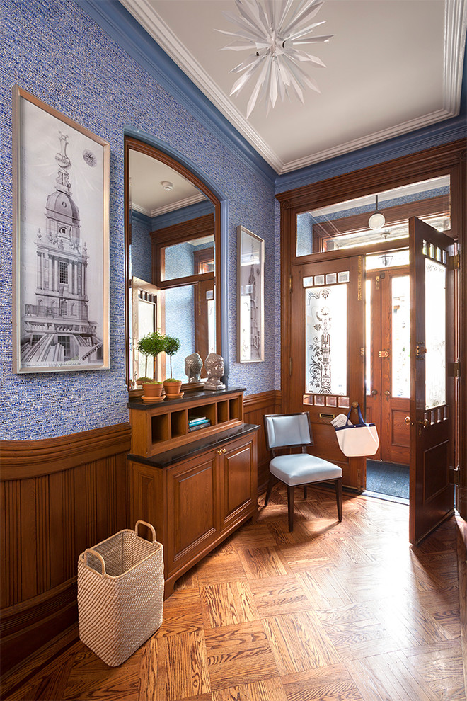 Mittelgroßes Klassisches Foyer mit blauer Wandfarbe, braunem Holzboden, Doppeltür und hellbrauner Holzhaustür in New York