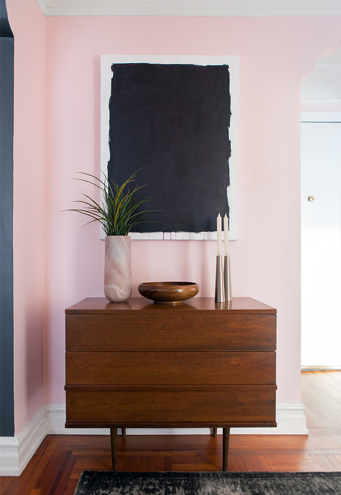 Diseño de distribuidor bohemio con paredes rosas y suelo de madera en tonos medios