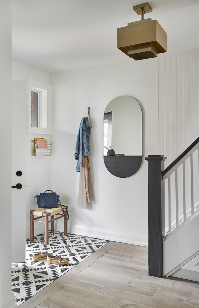 Imagen de entrada marinera con paredes blancas, suelo de madera clara, puerta simple, puerta blanca y suelo beige