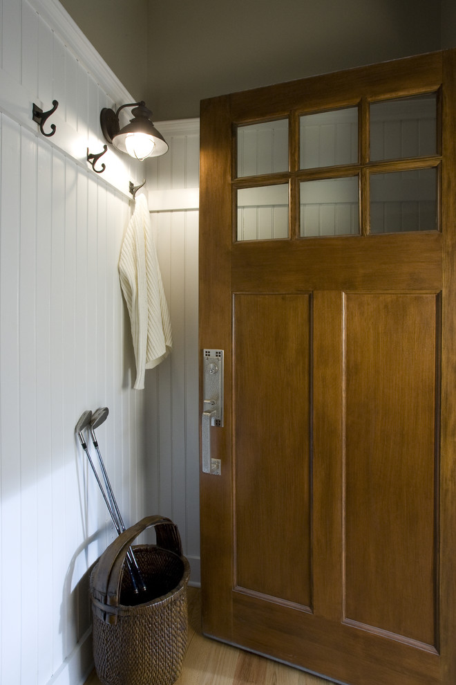 Пример оригинального дизайна: прихожая в классическом стиле с белыми стенами, одностворчатой входной дверью и входной дверью из дерева среднего тона