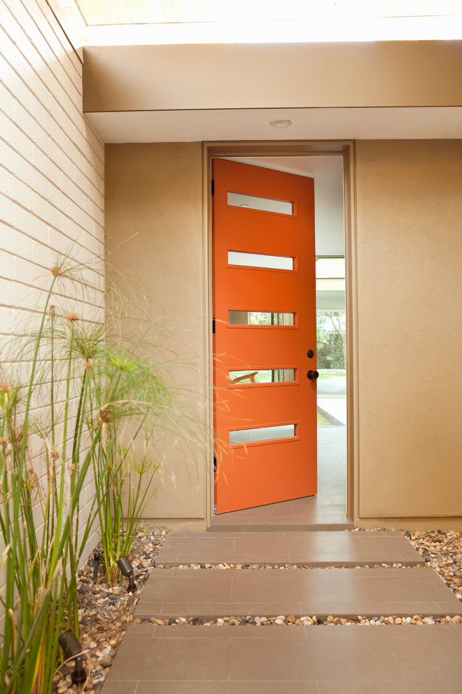 Immagine di un ingresso o corridoio minimalista con una porta arancione