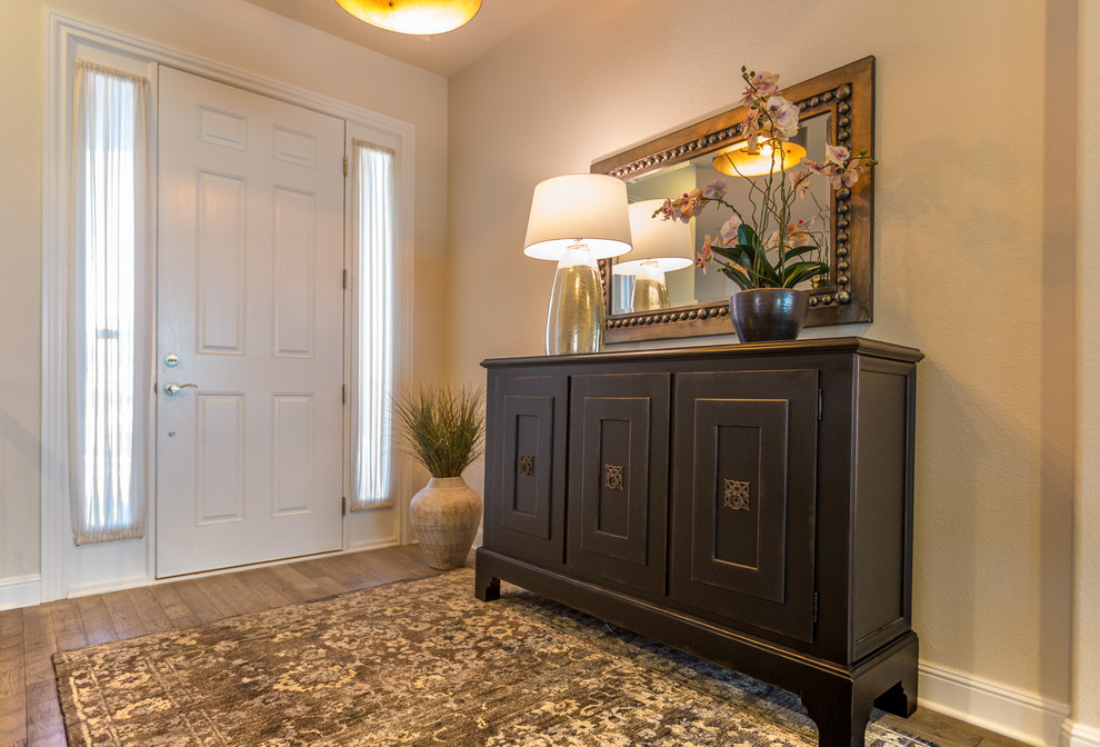 Modelo de hall clásico renovado de tamaño medio con paredes beige, suelo de madera en tonos medios, puerta simple y puerta blanca