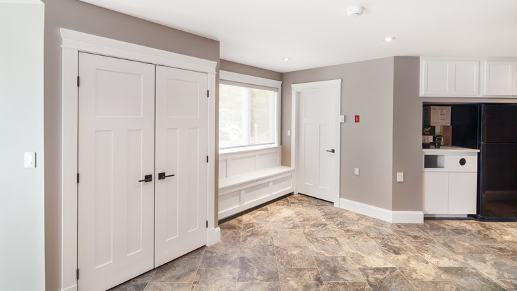 Example of a mid-sized transitional linoleum floor entryway design in Other with beige walls and a black front door