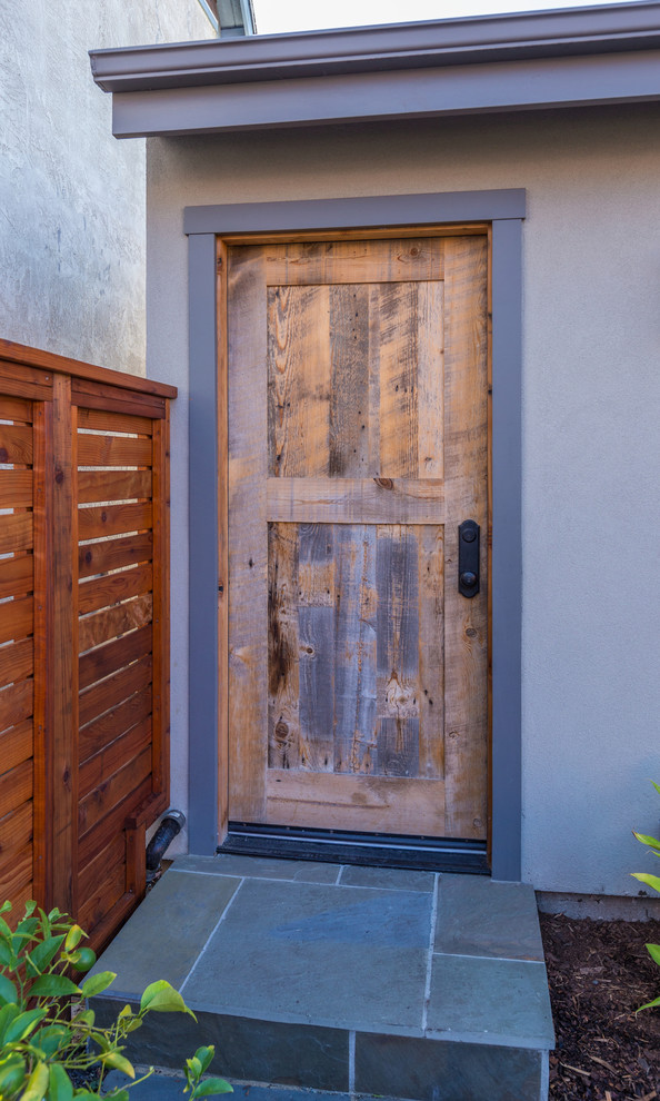 Exemple d'une petite porte d'entrée chic avec un mur beige, sol en béton ciré, une porte simple et une porte en bois foncé.