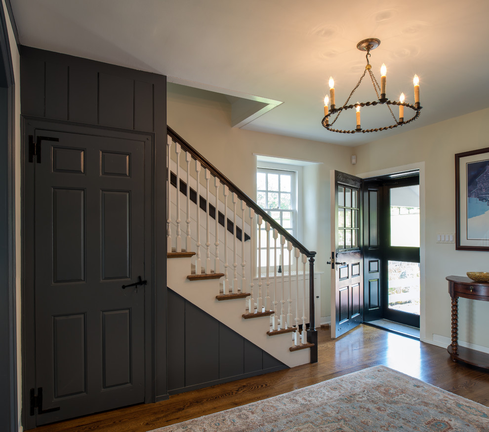 Geräumiges Klassisches Foyer mit beiger Wandfarbe, schwarzer Haustür, braunem Holzboden und Einzeltür in Philadelphia