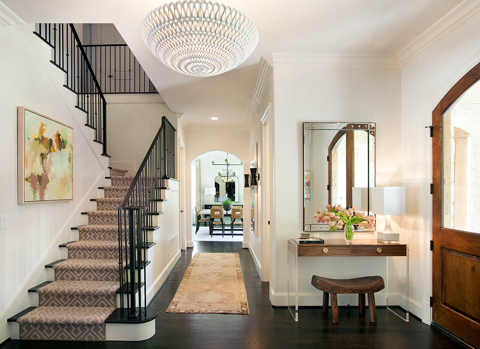 Design ideas for a medium sized traditional foyer in Dallas with white walls, dark hardwood flooring, a medium wood front door and feature lighting.