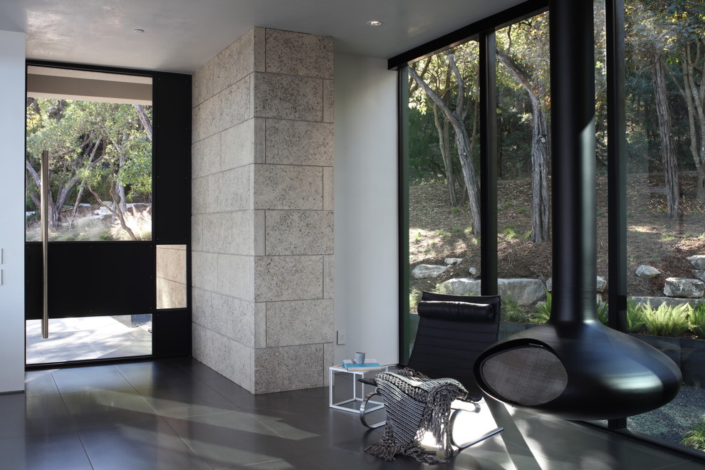 Immagine di un ingresso design con pareti bianche, pavimento in gres porcellanato, una porta a pivot, una porta in metallo e pavimento grigio