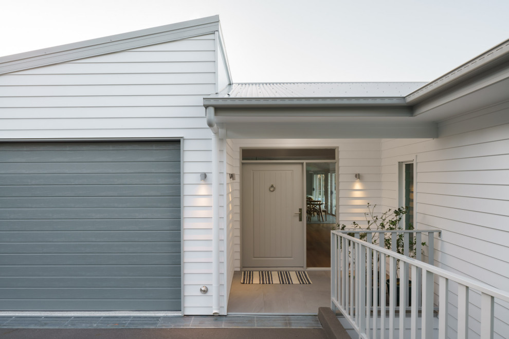Moderner Eingang mit weißer Wandfarbe, Keramikboden, grauer Haustür, grauem Boden und Holzwänden in Sunshine Coast