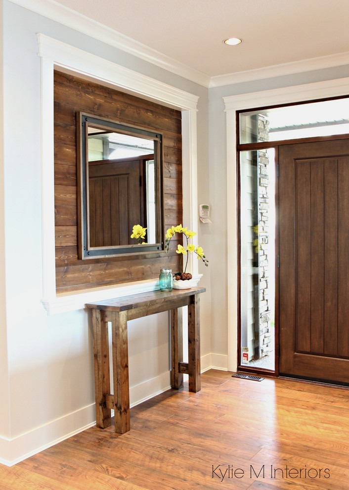 Diseño de distribuidor tradicional renovado de tamaño medio con paredes grises, suelo laminado, puerta simple, puerta marrón y suelo marrón