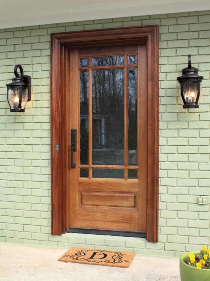 Modelo de puerta principal de estilo americano de tamaño medio con paredes grises, suelo de cemento, puerta simple y puerta de madera clara