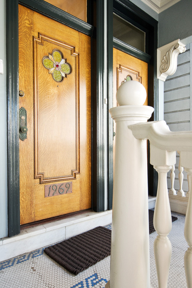 Источник вдохновения для домашнего уюта: входная дверь среднего размера в викторианском стиле с синими стенами, полом из керамогранита, одностворчатой входной дверью, входной дверью из дерева среднего тона и разноцветным полом