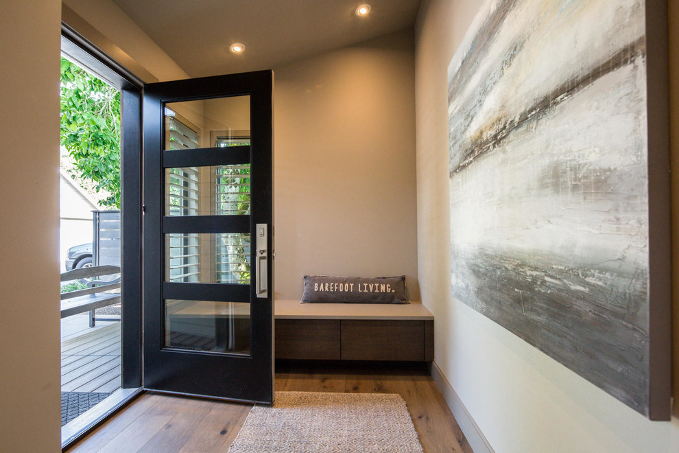 Immagine di una porta d'ingresso chic di medie dimensioni con pareti beige, pavimento in legno massello medio, una porta singola, una porta in vetro e pavimento marrone