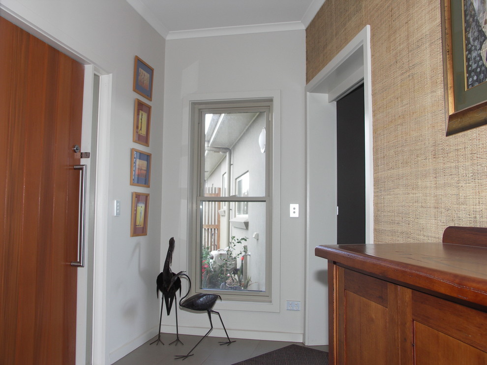 Стильный дизайн: фойе среднего размера в современном стиле с белыми стенами, полом из керамогранита, одностворчатой входной дверью и входной дверью из темного дерева - последний тренд