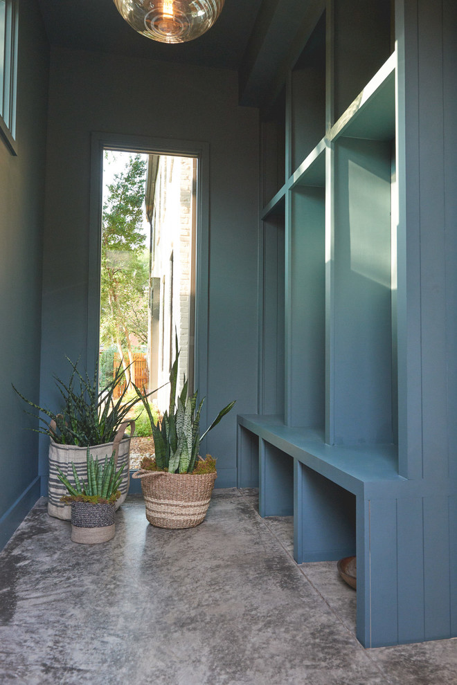 Aménagement d'une entrée contemporaine avec un mur bleu et sol en béton ciré.