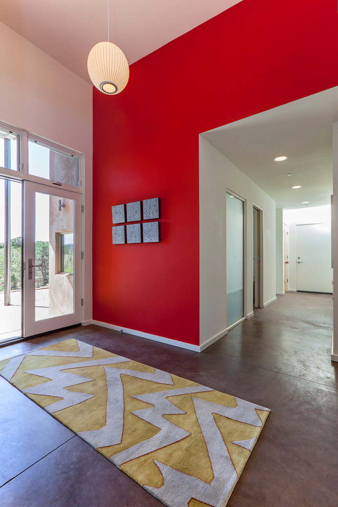 Свежая идея для дизайна: фойе среднего размера в современном стиле с красными стенами, бетонным полом и двустворчатой входной дверью - отличное фото интерьера