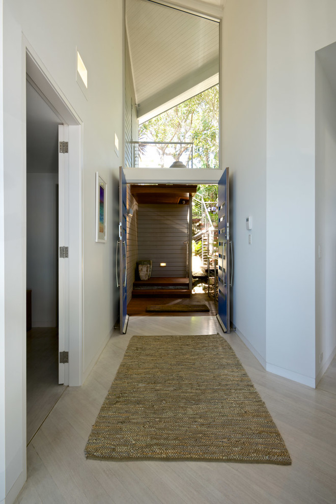 Esempio di un ingresso stile marino di medie dimensioni con pareti bianche, parquet chiaro, una porta a due ante, una porta blu e pavimento bianco