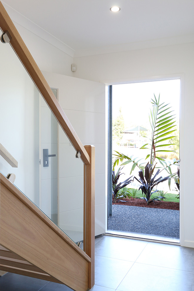 Example of a mid-sized trendy porcelain tile entryway design in Brisbane with white walls and a white front door