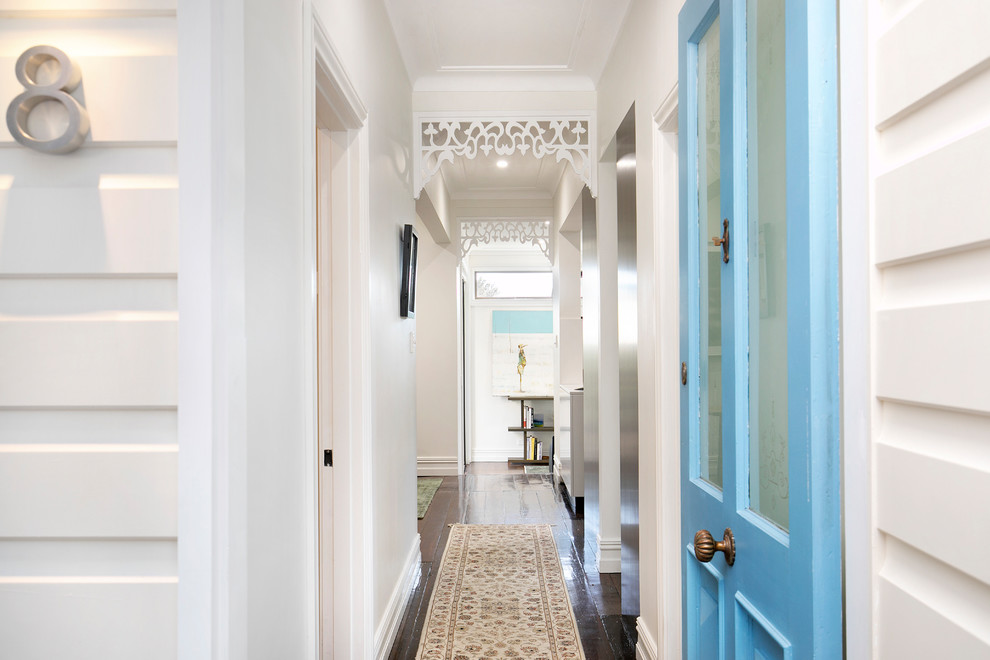 Imagen de puerta principal tradicional renovada con paredes blancas, suelo de madera oscura, puerta simple, puerta azul y suelo marrón