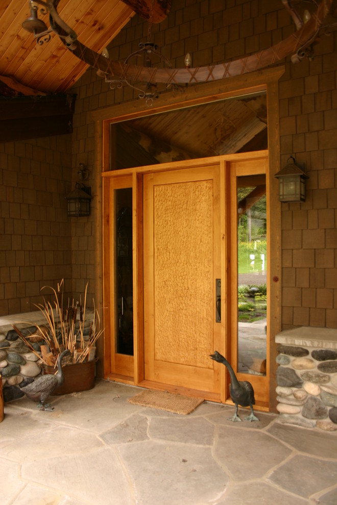 Esempio di una porta d'ingresso stile rurale con una porta singola e una porta in legno chiaro