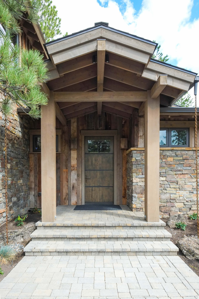 Inspiration pour une porte d'entrée chalet de taille moyenne avec un mur multicolore, une porte simple et une porte en bois brun.