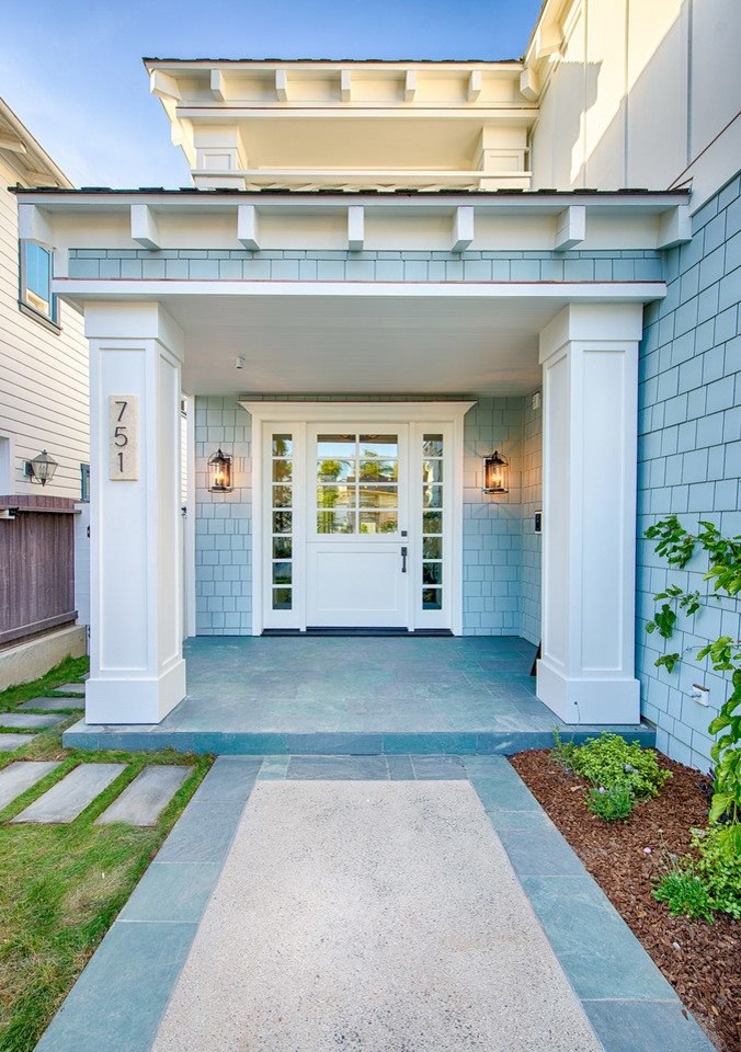Haustür mit blauer Wandfarbe, Betonboden, Drehtür und weißer Haustür in Los Angeles