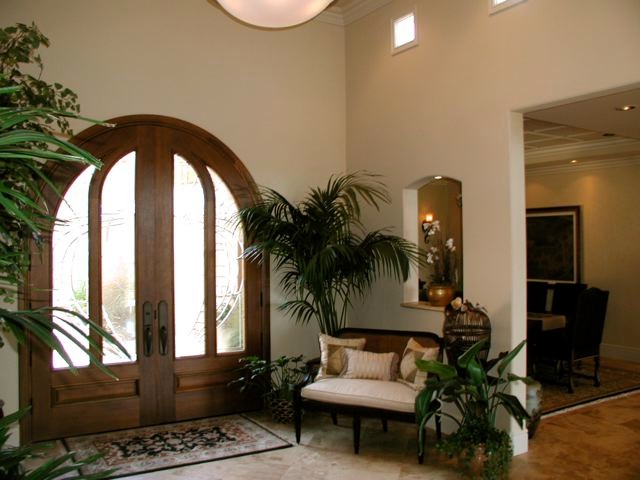 Große Klassische Haustür mit Doppeltür, dunkler Holzhaustür, beiger Wandfarbe und Kalkstein in Orange County
