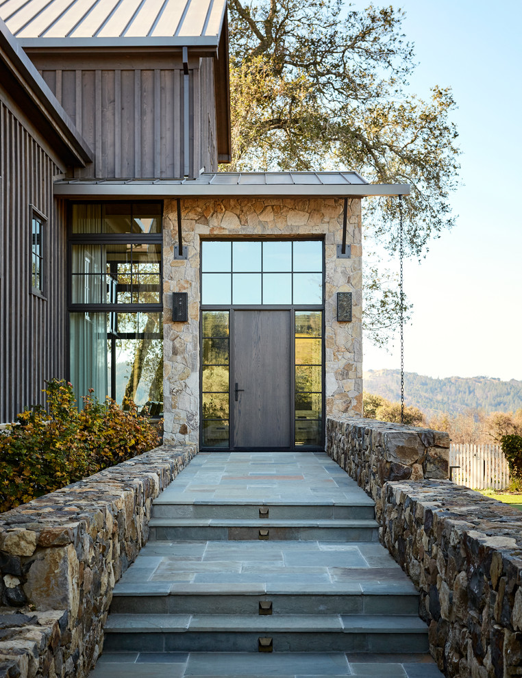 Foto di una porta d'ingresso country con pareti beige, una porta singola, una porta in legno scuro e pavimento grigio
