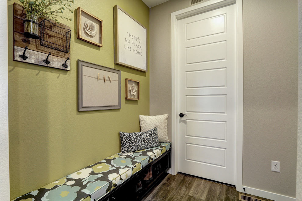 Idée de décoration pour un hall d'entrée champêtre de taille moyenne avec un mur multicolore, un sol en bois brun, une porte simple, une porte blanche et un sol marron.