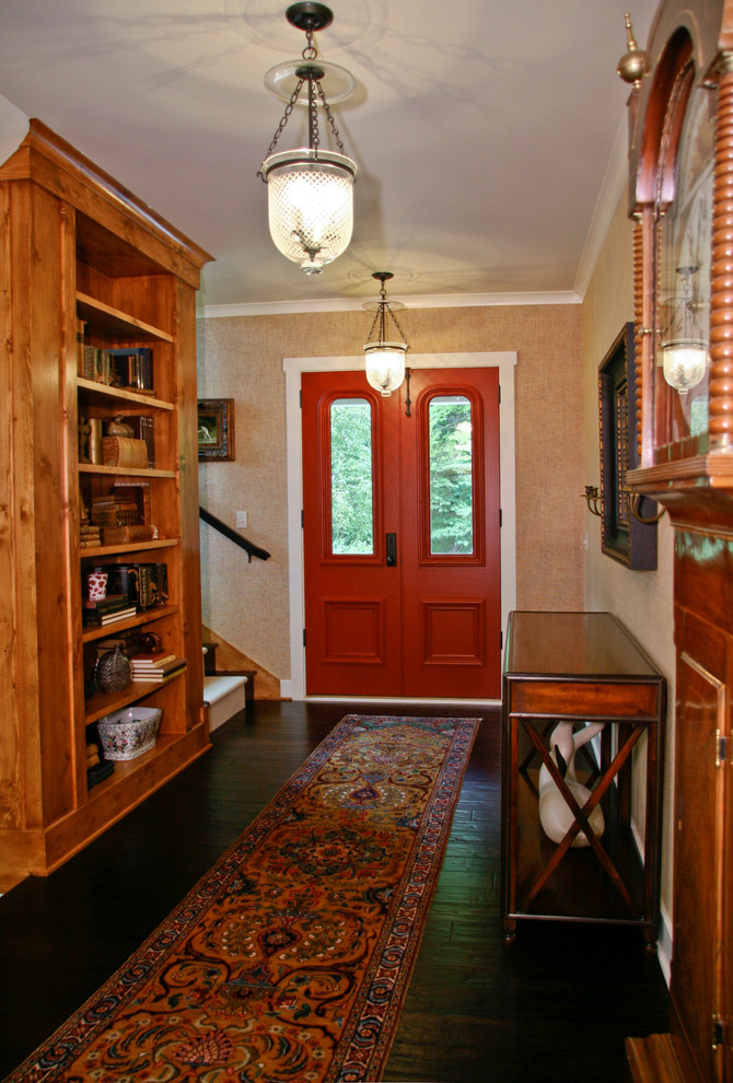 Foto de distribuidor tradicional de tamaño medio con suelo de madera oscura, puerta doble, puerta roja, paredes beige y suelo marrón