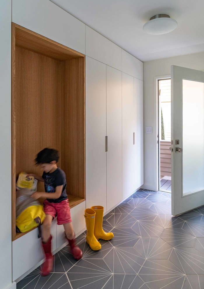 Inspiration for a 1960s porcelain tile and gray floor entryway remodel in New York with white walls and a glass front door