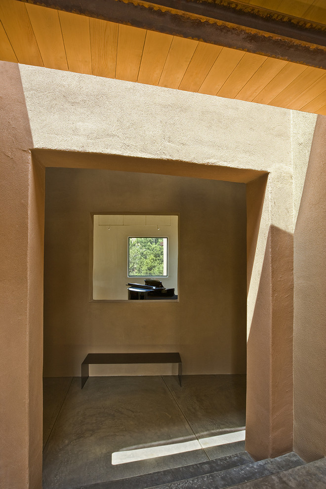 This is an example of a medium sized contemporary foyer in Albuquerque with brown walls and concrete flooring.