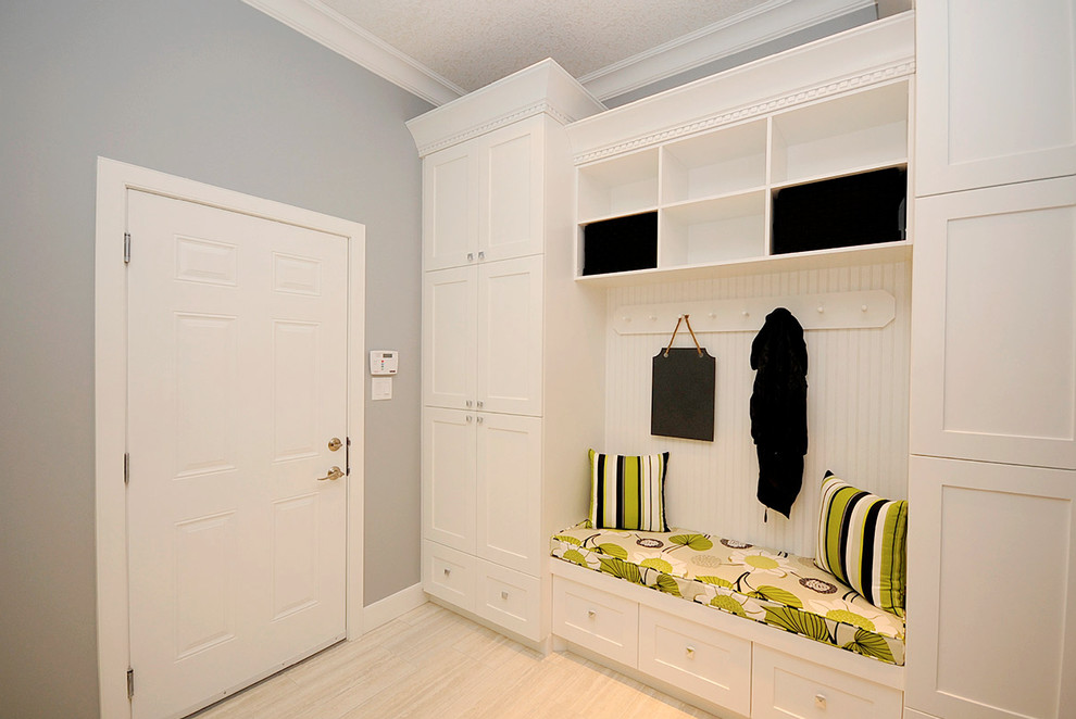 Inspiration pour une entrée design de taille moyenne avec un vestiaire, un mur gris, un sol en carrelage de porcelaine, une porte simple, une porte blanche et un sol beige.