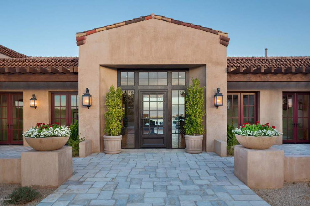 Inspiration for a mediterranean entryway remodel in Phoenix with a glass front door
