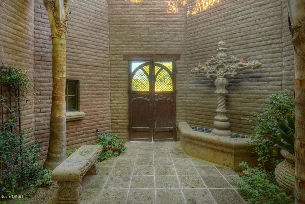 Example of a small mountain style entryway design in Phoenix with brown walls and a medium wood front door