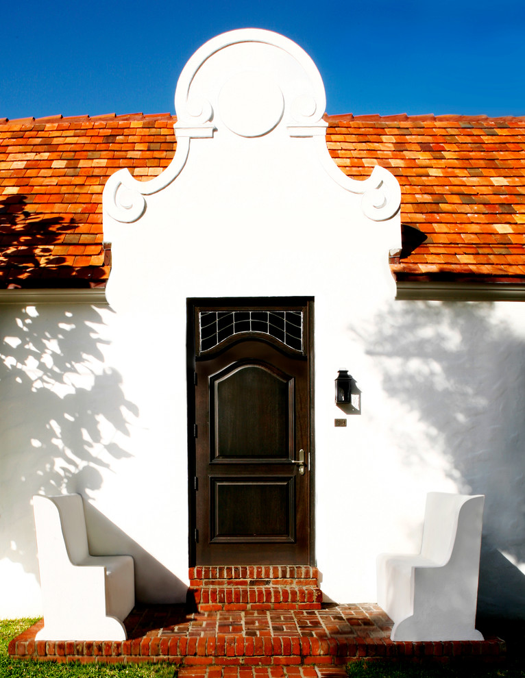 Idée de décoration pour une porte d'entrée méditerranéenne avec une porte simple et une porte en bois foncé.