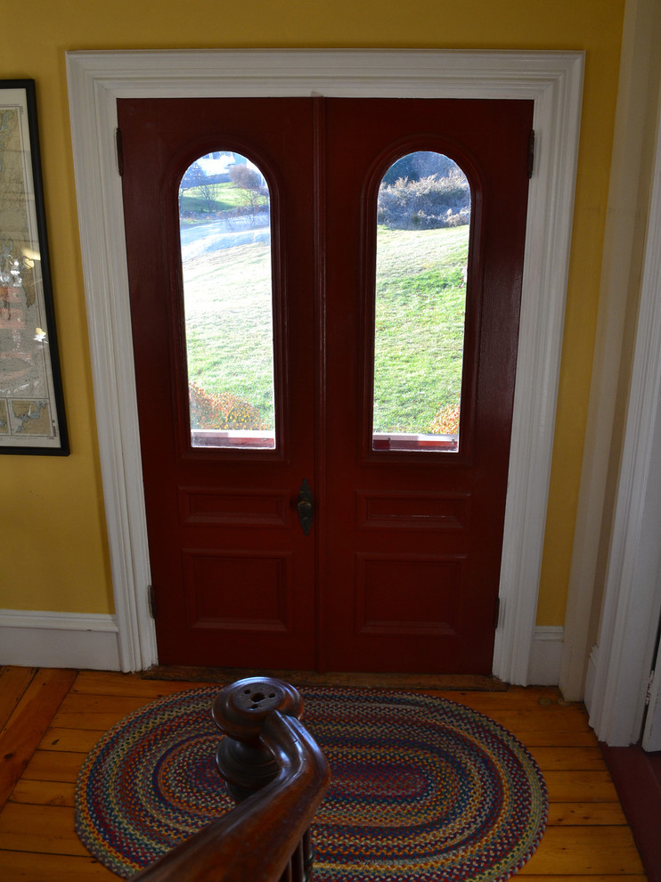 Inspiration for a mid-sized timeless medium tone wood floor entryway remodel in Boston with yellow walls and a red front door