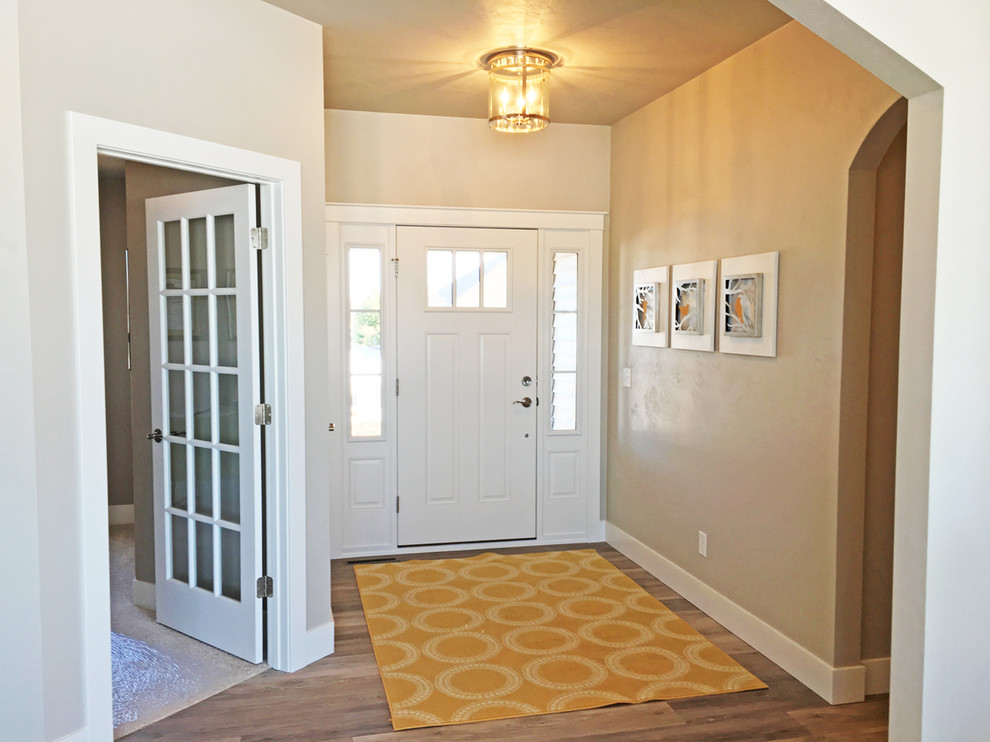 Imagen de puerta principal de estilo americano grande con paredes beige, suelo de madera en tonos medios, puerta simple y puerta blanca