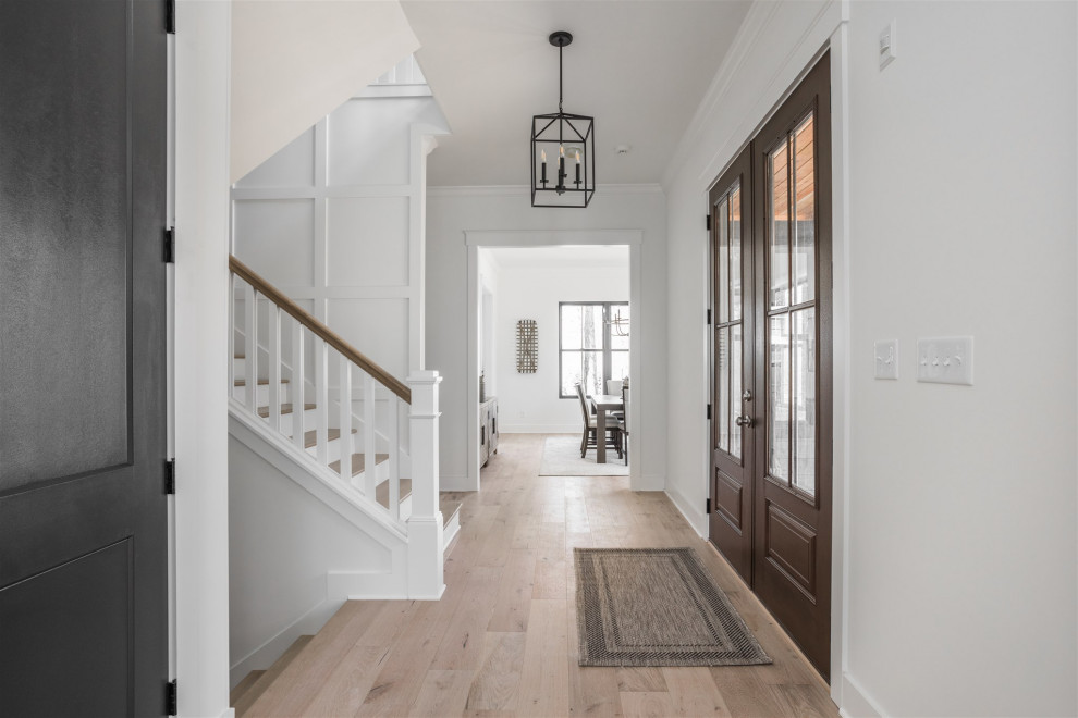 Inspiration for a large rural hallway in Indianapolis with white walls, medium hardwood flooring, a double front door, a medium wood front door and beige floors.