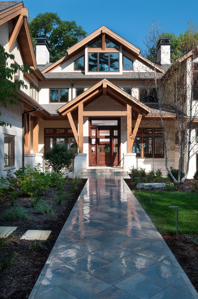 This is an example of a large contemporary front door in Grand Rapids with a single front door and a dark wood front door.