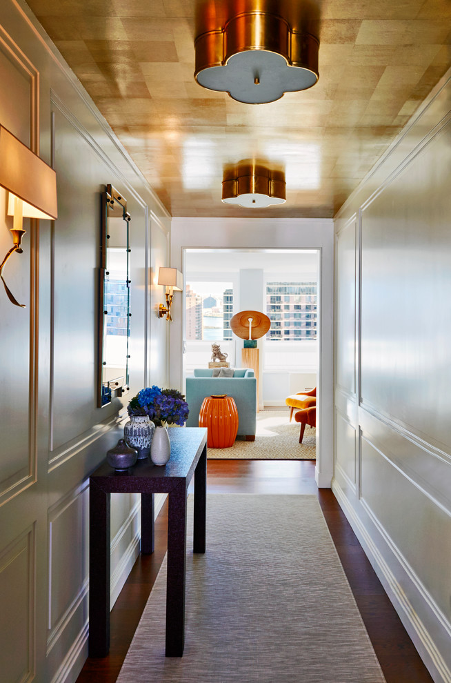 Inspiration for a medium sized classic hallway in New York with white walls, a single front door, brown floors, dark hardwood flooring and feature lighting.