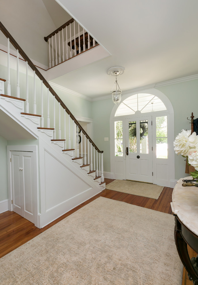 This is an example of a medium sized classic front door with green walls, dark hardwood flooring, a single front door, a white front door and brown floors.