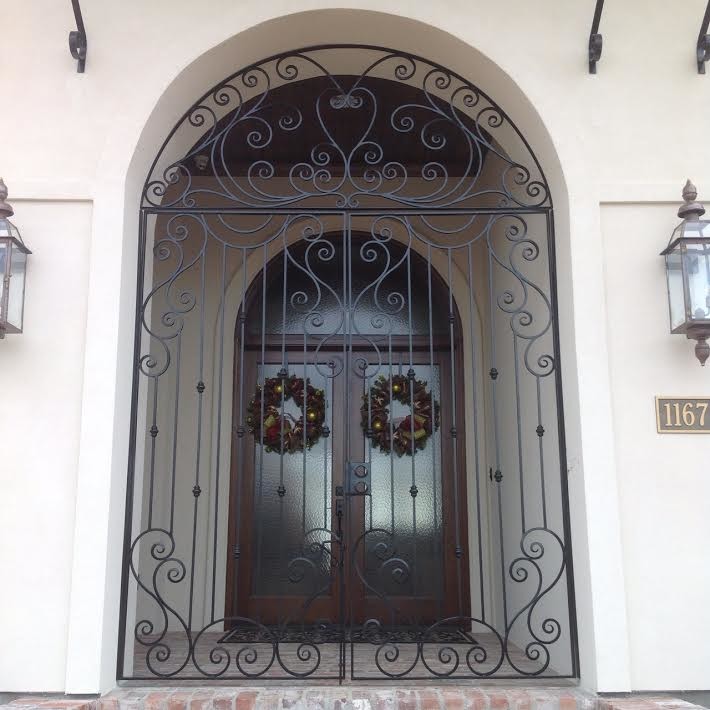 Foto på en stor vintage ingång och ytterdörr, med tegelgolv, en dubbeldörr, metalldörr och brunt golv