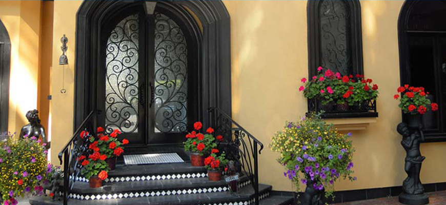 Ejemplo de puerta principal mediterránea grande con suelo de pizarra, puerta doble y puerta negra