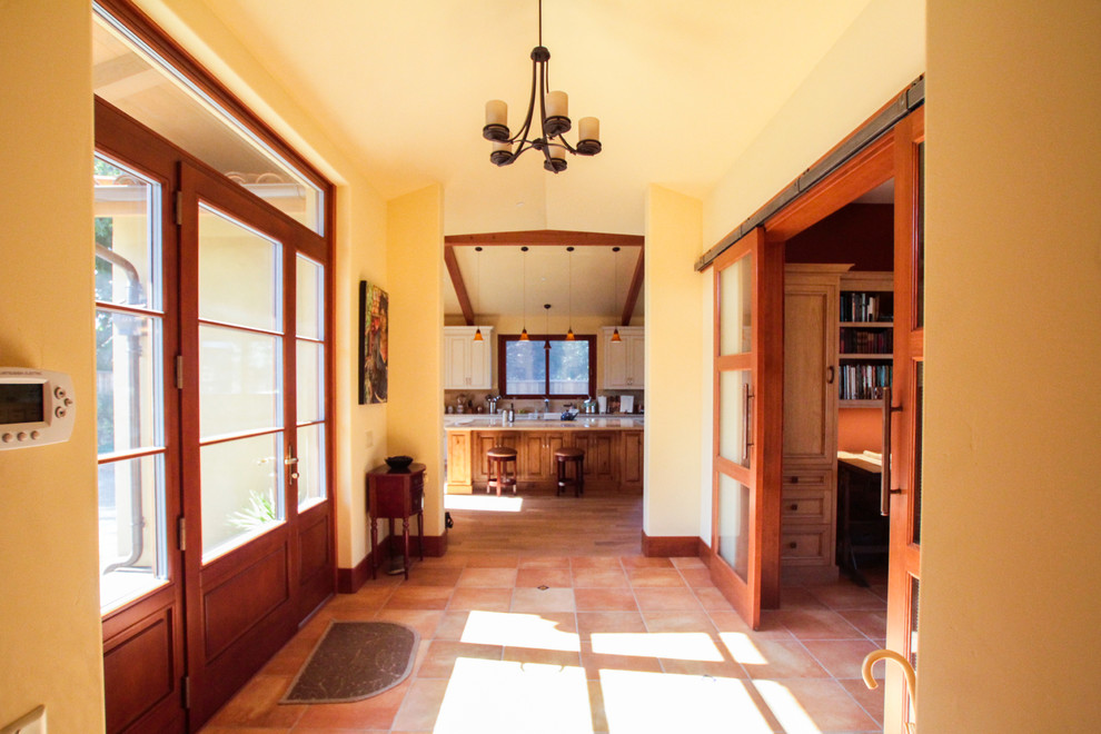 Ejemplo de puerta principal mediterránea de tamaño medio con paredes beige, suelo de travertino, puerta simple, puerta de madera en tonos medios y suelo marrón