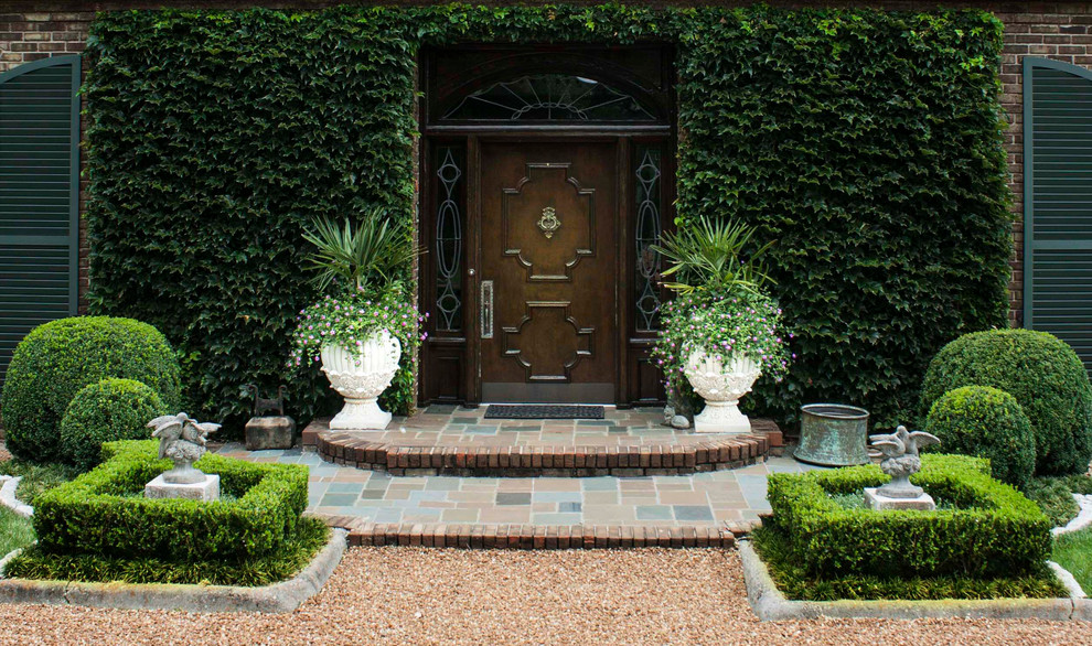 На фото: входная дверь среднего размера в классическом стиле с одностворчатой входной дверью и входной дверью из темного дерева