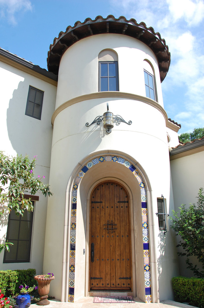 Ejemplo de puerta principal mediterránea grande con paredes blancas, suelo de baldosas de terracota, puerta simple y puerta de madera en tonos medios