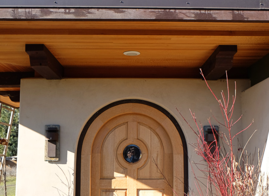 Modelo de entrada tradicional con puerta simple y puerta de madera clara